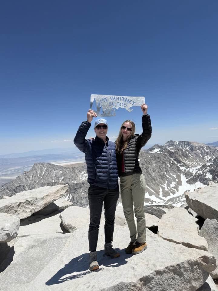 Whitney and her father Mark at the summit of Mount Whitney, holding the summit marker.